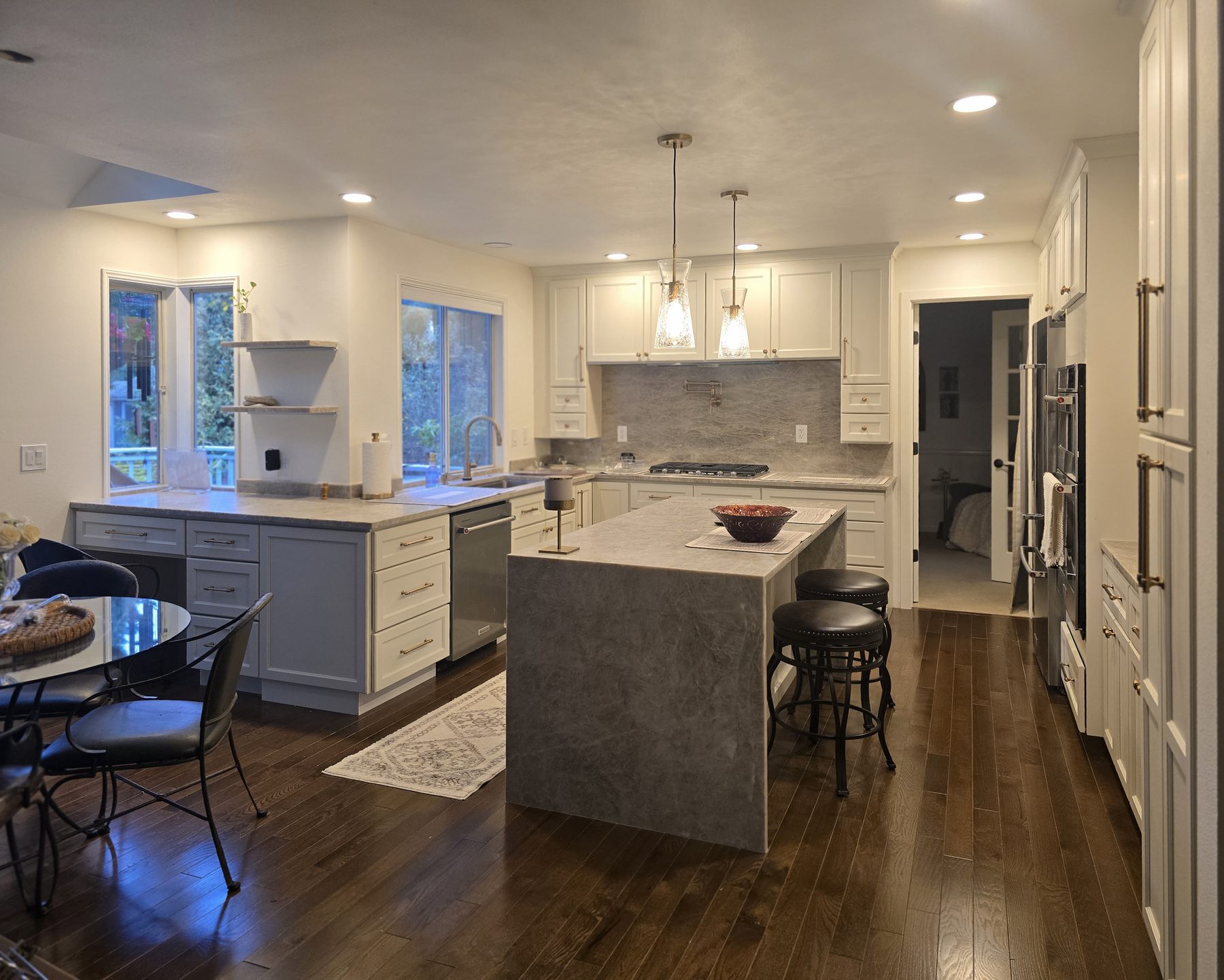 After: white shaker kitchen with a stone waterfall island